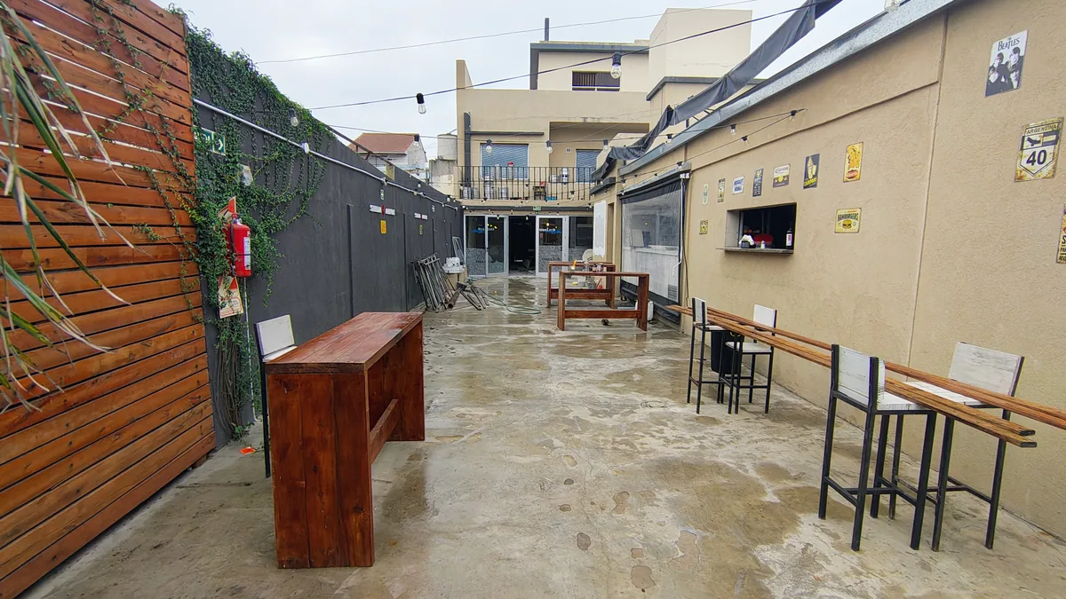Restobar Obelius - Pasillo exterior con mesas altas y ventanal de atención